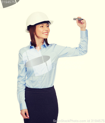 Image of businesswoman in helmet writing on virtual screen