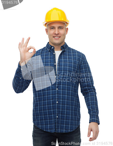 Image of smiling male builder in helmet showing ok sign