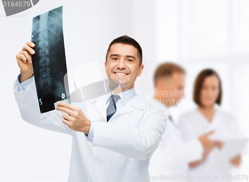 Image of smiling male doctor holding x-ray at hospital