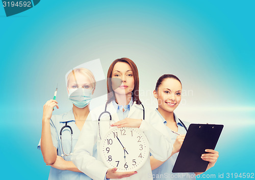 Image of calm female doctor and nurses with wall clock