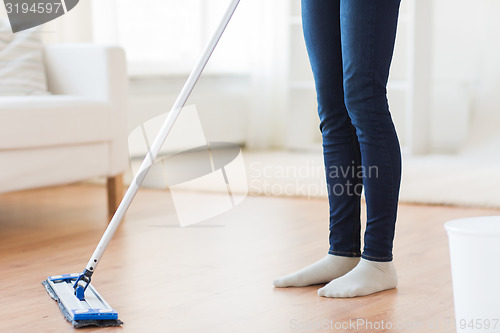 Image of close up of woman with mop cleaning floor at home