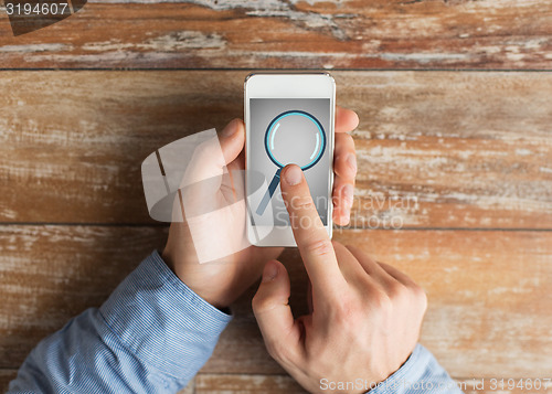 Image of close up of hands with magnifier on smartphone