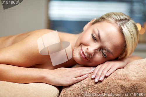 Image of young woman lying on massage table in spa