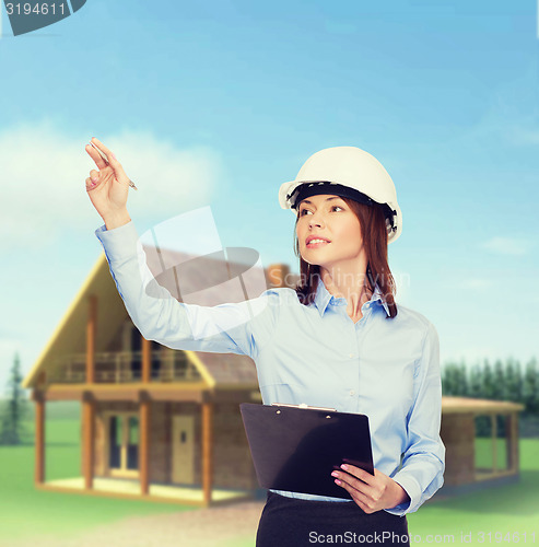 Image of smiling businesswoman in helmet with clipboard