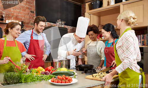 Image of happy friends and chef cook cooking in kitchen