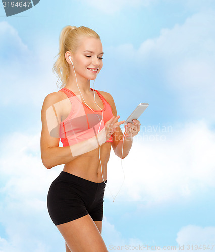 Image of smiling sporty woman with smartphone and earphones