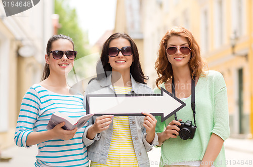 Image of smiling teenage girls with white arrow outdoors