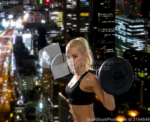 Image of sporty woman exercising with barbell