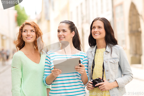 Image of smiling teenage girls with tablet pc and camera