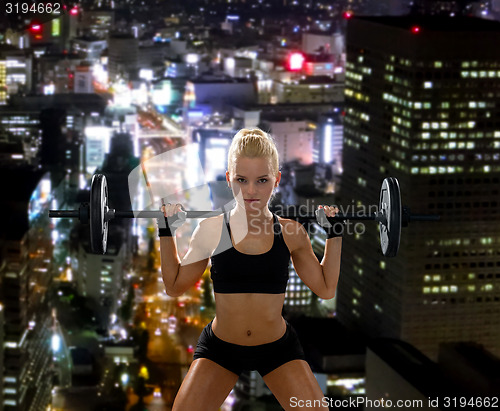 Image of sporty woman exercising with barbell