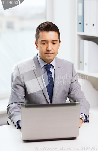 Image of businessman working with laptop in office