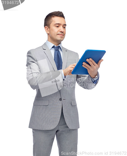 Image of happy businessman in suit holding tablet pc