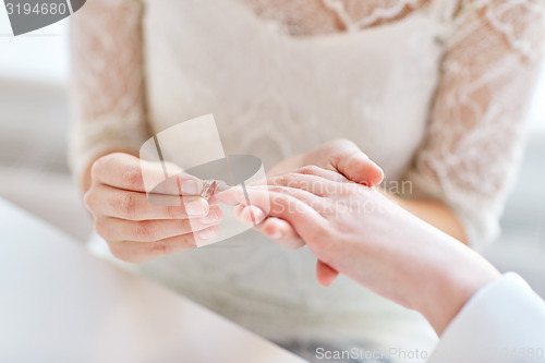 Image of close up of lesbian couple hands with wedding ring