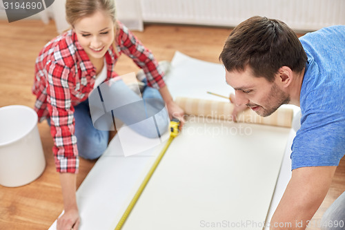 Image of close up of couple measuring wallpaper