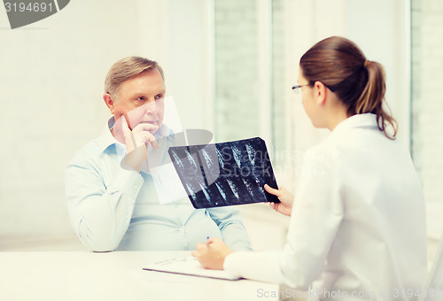 Image of female doctor with old man looking at x-ray