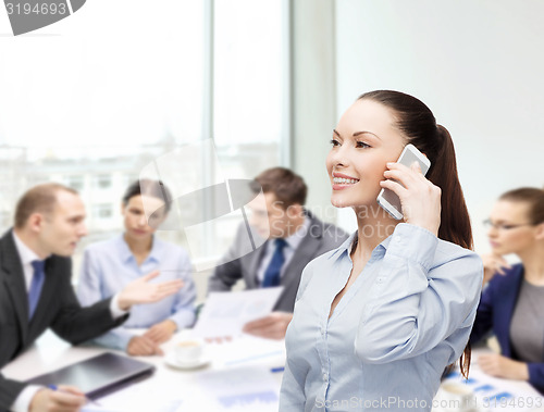 Image of young smiling businesswoman with smartphone