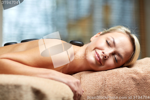 Image of close up of woman having hot stone massage in spa