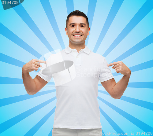 Image of smiling man in t-shirt pointing fingers on himself