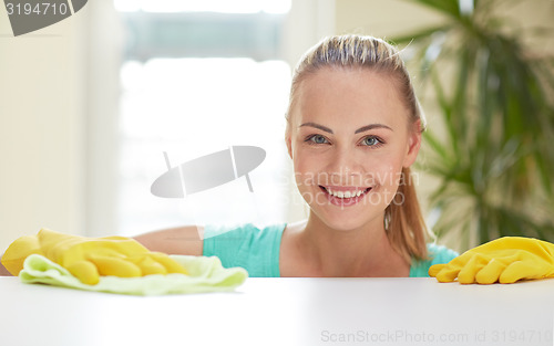 Image of happy woman cleaning table at home kitchen