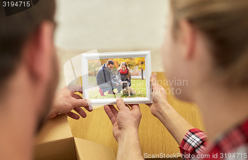 Image of close up of happy couple looking at family photo