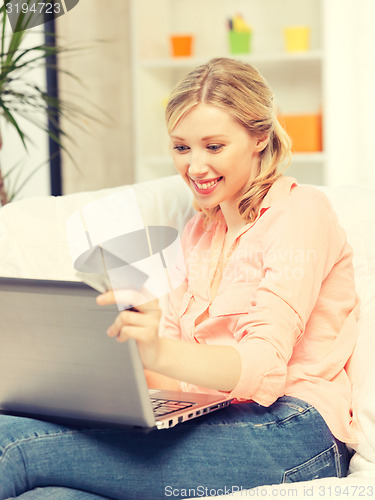 Image of happy woman with laptop computer and credit card