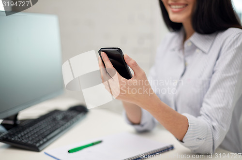 Image of close up of woman texting on smartphone at office