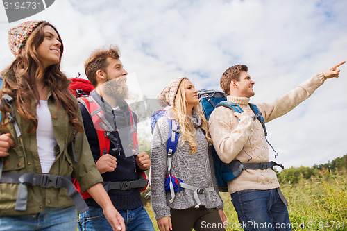 Image of group of smiling friends with backpacks hiking