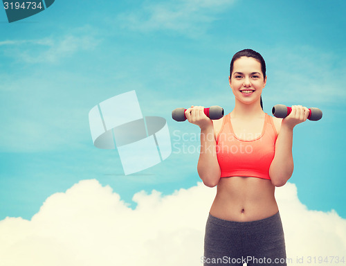 Image of young sporty woman with light dumbbells