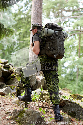 Image of young soldier with backpack in forest