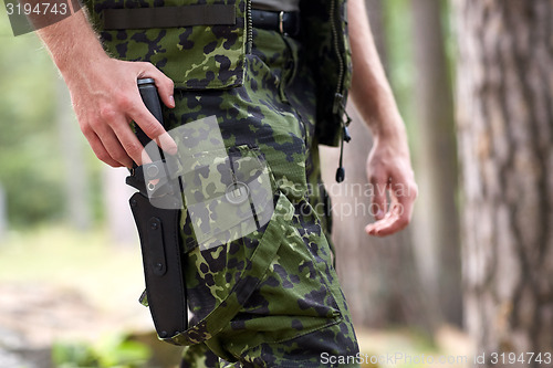 Image of close up of soldier or hunter with knife in forest