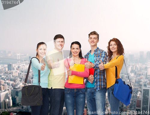 Image of group of smiling teenagers showing thumbs up