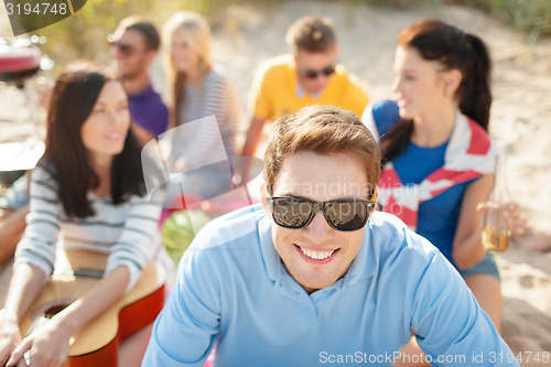 Image of group of happy friends having fun on beach