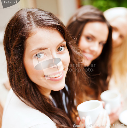 Image of beautiful girls drinking coffee in cafe