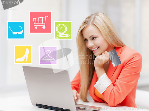 Image of happy businesswoman with laptop and credit card