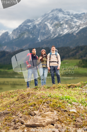 Image of group of smiling friends with backpacks hiking