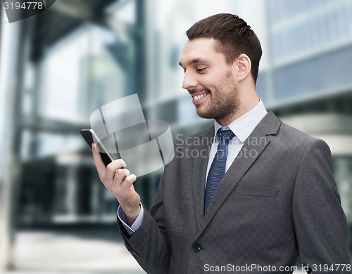 Image of young smiling businessman with smartphone