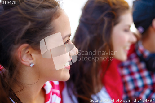 Image of smiling teenage girl outdoors with friends