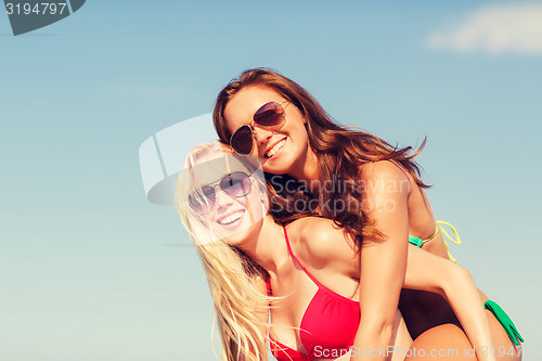 Image of two smiling young women on beach