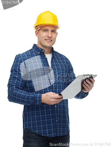 Image of smiling male builder in helmet with clipboard