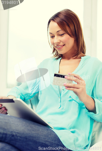 Image of happy woman with tablet pc and credit card at home