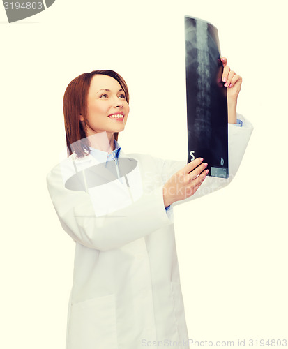 Image of smiling female doctor looking at x-ray