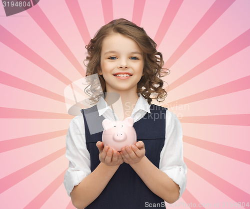 Image of happy girl holding piggy bank on palms