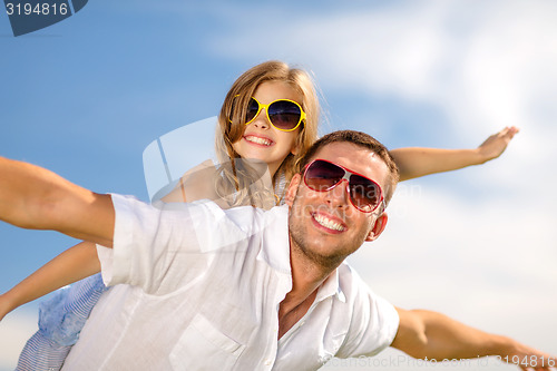 Image of happy father and child in sunglasses over blue sky