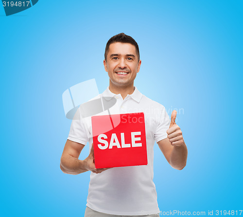 Image of smiling man with red sale sigh showing thumbs up