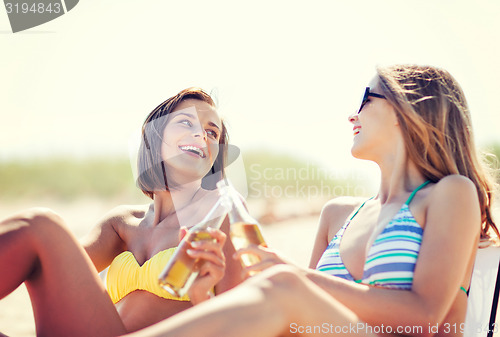 Image of girls with drinks on the beach chairs