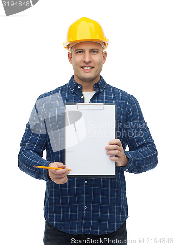 Image of smiling male builder in helmet with clipboard