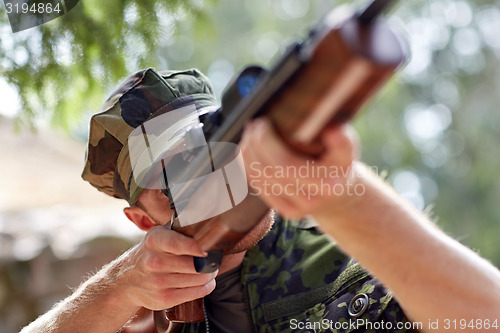 Image of soldier or hunter shooting with gun in forest