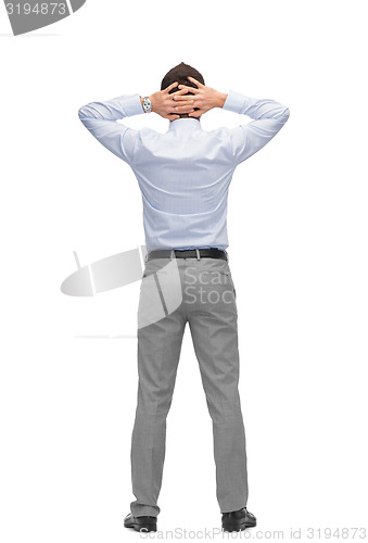 Image of businessman with hands behind his head from back
