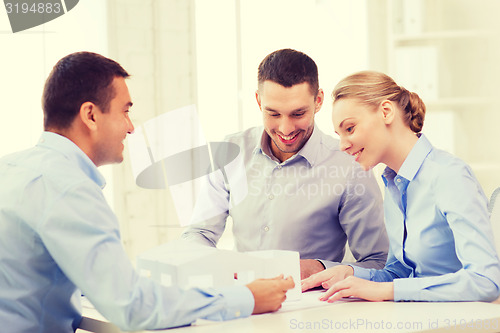 Image of couple looking at model of their house at office