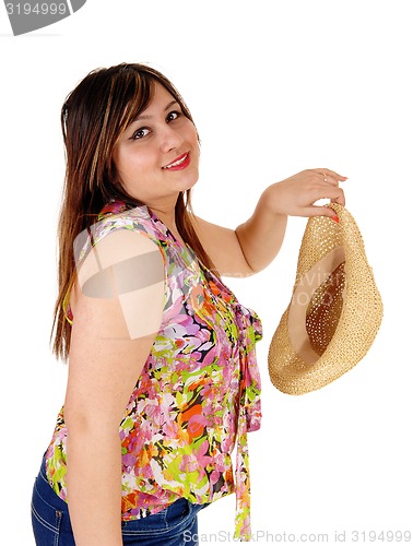 Image of Woman holding her straw hat.